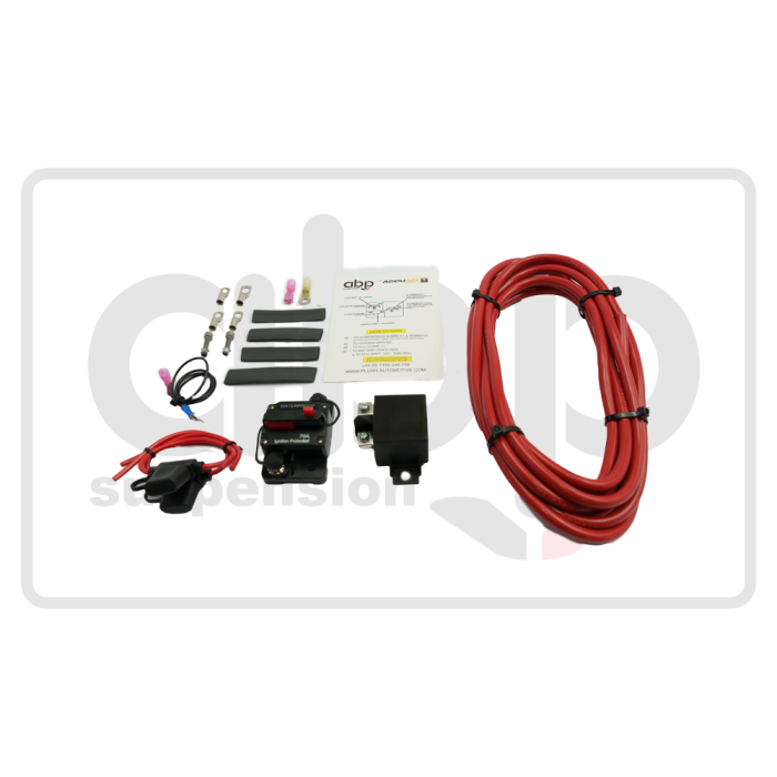 Electrical wiring kit components lying on a white surface, including a red cable coil, connectors, installation guide labeled "alb suspension," black terminal covers, and a circuit breaker. Text: "abl suspension," "Install the clip - positive wire," WWW. ALB SUSPENSION.COM