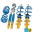 Car suspension parts: Two shock absorbers and two coil springs in yellow and blue, arranged beside smaller components. “BILSTEIN” logo with text and a shock absorber graphic is in the bottom right.