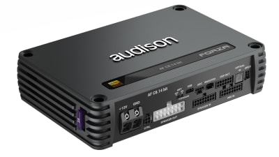 A black Audison amplifier AF C8.14 bit, featuring various ports and connectors, sits on a white surface, surrounded by a modern, clean environment.
