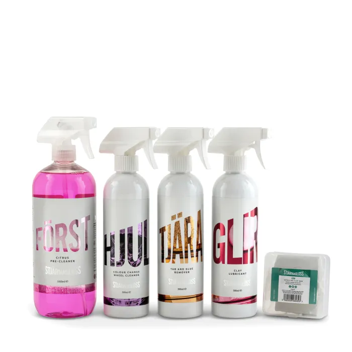 Five Stjärnagloss cleaning products arranged side by side. Four have trigger spray bottles labeled "FÖRST," "HJUL," "TJÄRA," and "GLIR," while one item is a clay bar in a branded box.