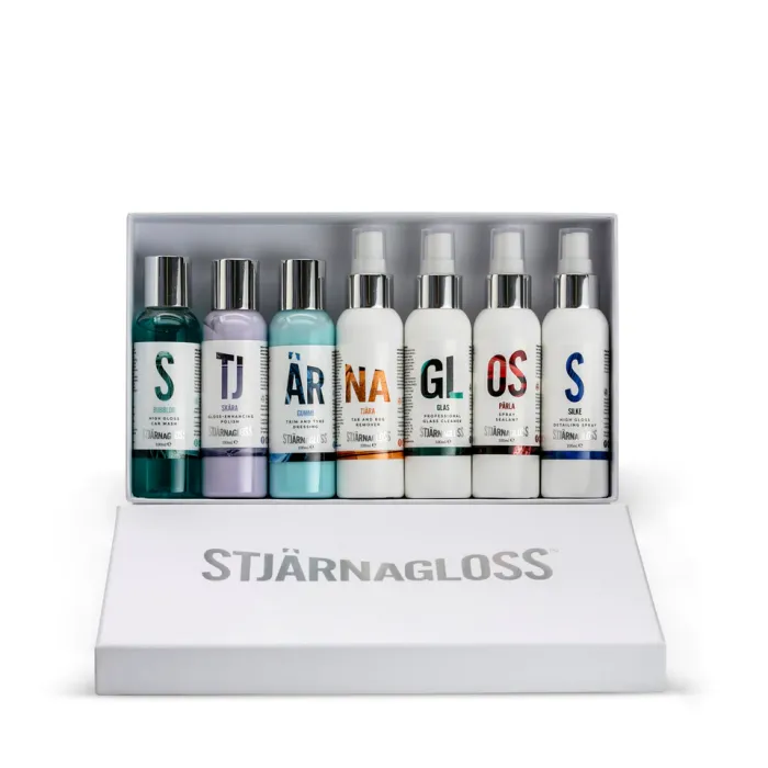 A set of seven bottles labeled "STJÄRNAGLOSS" containing car cleaning products arranged in an open white box. Each bottle has a different color marking and specific name like “BUBBLOR” and “SISÄRA.”