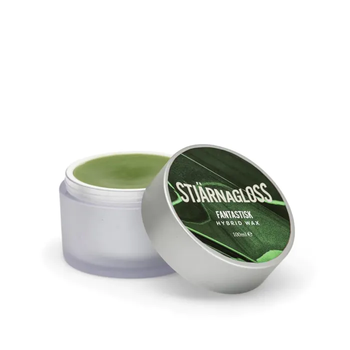 A small container with a green substance, identified as "STJÄRNAGLOSS FANTASTISK HYBRID WAX 100ml," has its lid partially removed, revealing the wax inside, set against a plain white background.