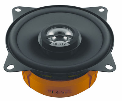 A black Hertz car audio speaker with an orange base is displayed. The speaker has a circular cone structure, four mounting holes at the corners, and is viewed from a slightly raised angle.
