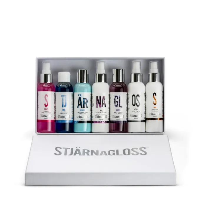 A set of eight labeled Stjärnagloss bottles of car care products are lined up in a white box, with colors ranging from pink to white. The box lid reads, "STJÄRNAGLOSS."