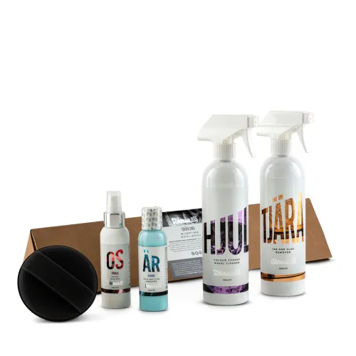Five automotive care products, including spray bottles, a small container, and a black applicator, are displayed on a white background next to a brown cardboard box. Text on bottles: - Hjul: COLOUR CHANGE WHEEL CLEANER SJÄRNGLASS 500ML - Tjära: TAR AND GLUE REMOVER SJÄRNGLASS 500ML - OS: PÄRLA - ÄR: GUMMI - Label behind: STJÄRNAGLOSS