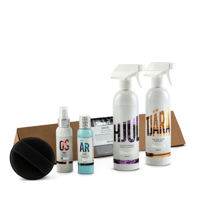 Five automotive care products, including spray bottles, a small container, and a black applicator, are displayed on a white background next to a brown cardboard box. Text on bottles: - Hjul: COLOUR CHANGE WHEEL CLEANER SJÄRNGLASS 500ML - Tjära: TAR AND GLUE REMOVER SJÄRNGLASS 500ML - OS: PÄRLA - ÄR: GUMMI - Label behind: STJÄRNAGLOSS