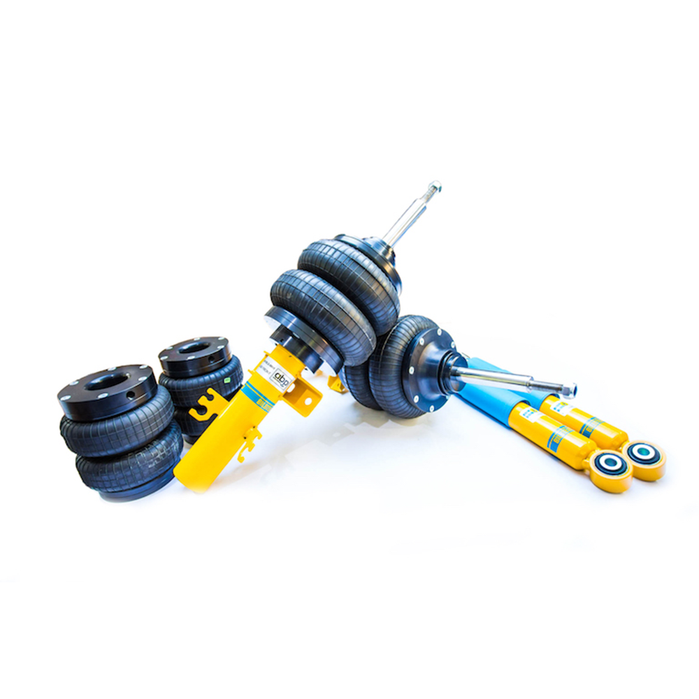 Yellow and blue automotive suspension components, including air springs and struts, arranged on a white background. Text on yellow component: "BILSTEIN B4".