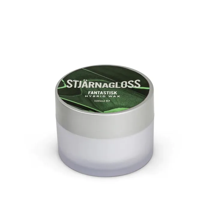 A small cylindrical container with a grey lid displays the text "STJÄRNAGLOSS FANTASTISK HYBRID WAX 100ml" on a green background, placed against a white surface.