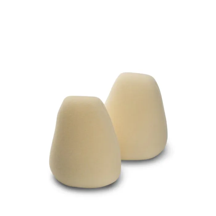 Two beige egg-shaped foam objects positioned on a plain white background.