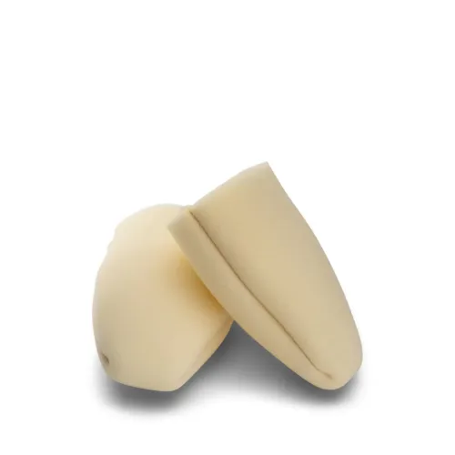 Two beige foam ear plugs rest on a plain white surface, positioned at an angle to each other, casting slight shadows.