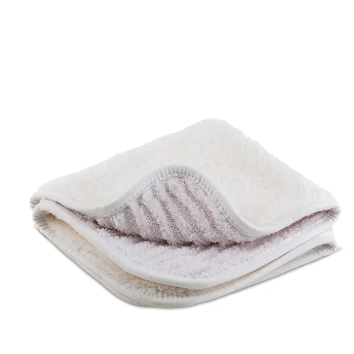 A folded, white fluffy towel with visible thick, soft fibers and stitched edges, placed on a plain white background. The interior texture appears ribbed, revealing its plush and cozy material.