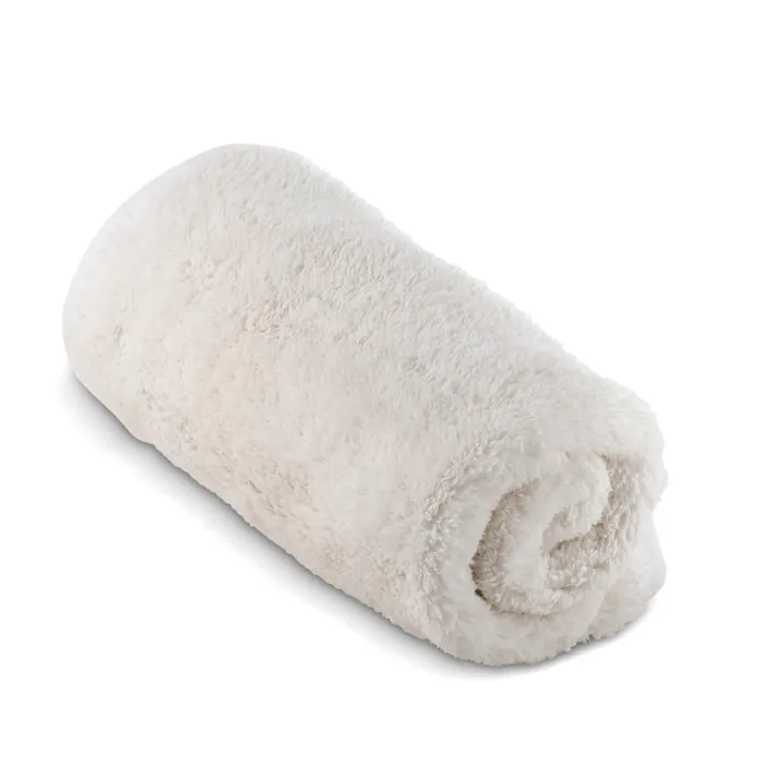 A rolled, fluffy, white towel sitting on a plain white background.