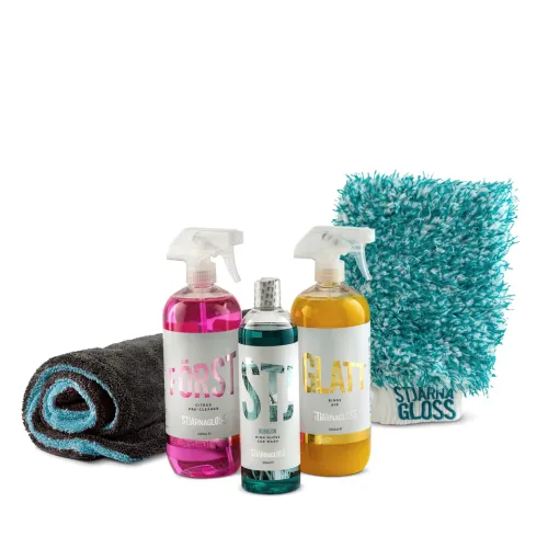 Car cleaning products include three bottles labeled "FÖRST," "STJÄRNA," and "GLATT" by STJÄRNAGLOSS, a rolled black and blue towel, and a blue and white microfiber mitt.