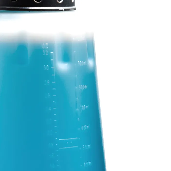 A blue container with measurement markings (32 oz, 900 ml) filled with blue liquid, topped by a black perforated lid, against a plain white background.