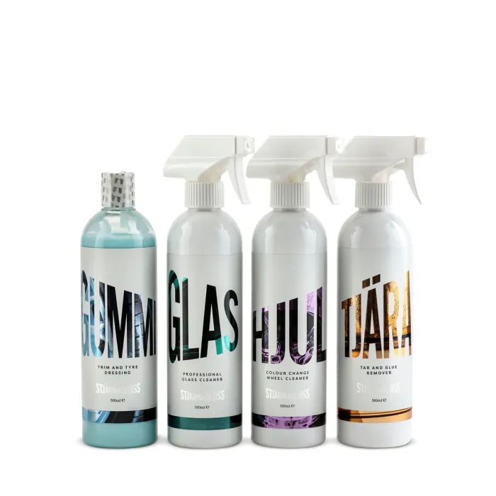 Four cleaning product bottles with large labels stand side by side; "GUMMI," "GLAS," "HJUL," and "TJÄRA." "Stjärnagloss" branding, a white background, and clear, white caps are visible.