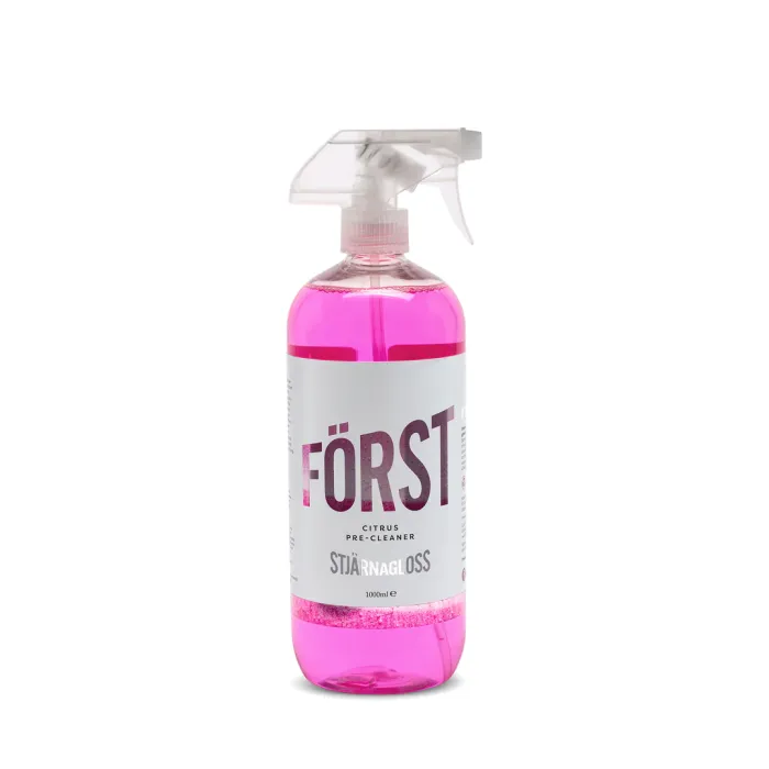 A pink liquid in a spray bottle labeled "FÖRST" Citrus Pre-Cleaner, "STJÄRNAGLOSS," 1000 ml, with a transparent trigger nozzle. The bottle stands against a plain white background.