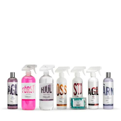 Seven cleaning products arranged in a line. Each product has a different color and label: "AVL", "FÖRST", "HJUL", "OSS", "STJ", "AGL", and "TÄRN." A package of grey and green cleaning wipes lies between "STJ" and "AGL." The context is a white background.