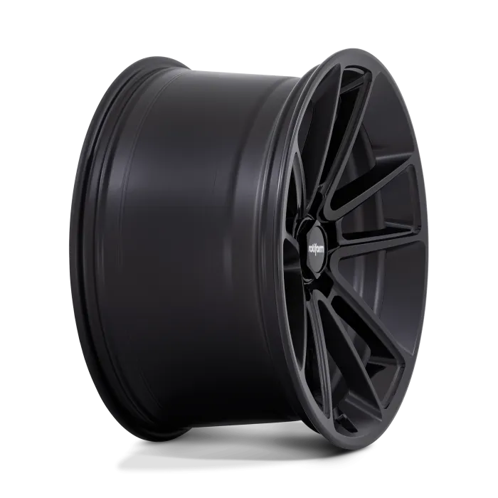 A black, multi-spoke car wheel rests against a seamless black background, displaying a logo with the text "rotiform" on the center cap.