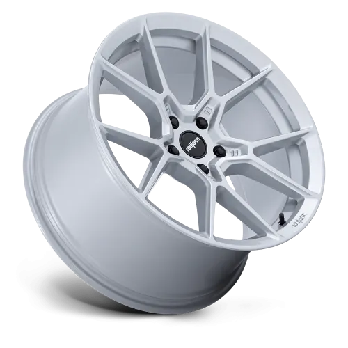 A silver, multi-spoke car wheel rim positioned at an angle, floating against a plain black background. The center cap displays the text "rotiform."