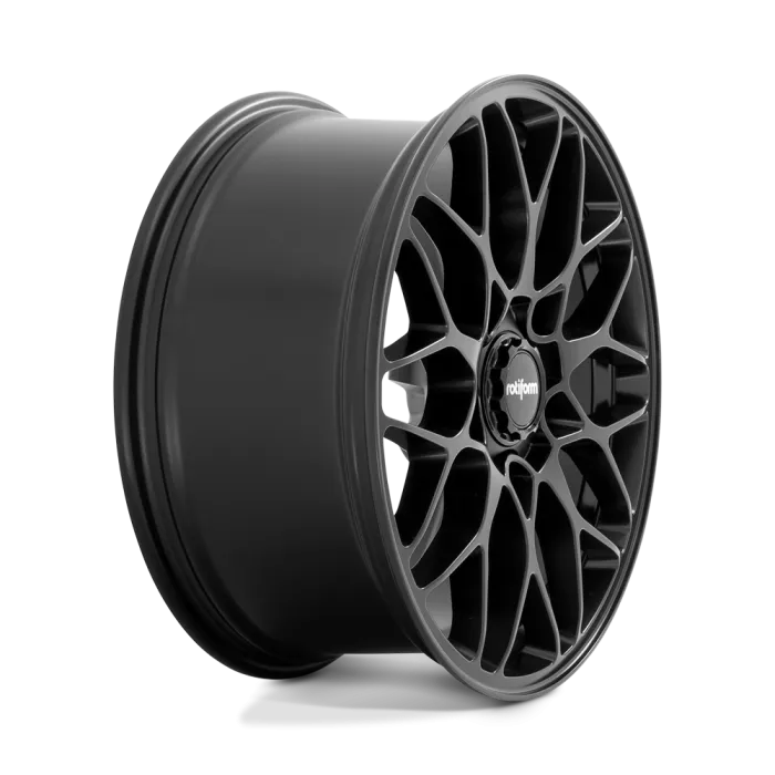 A black, multi-spoke car wheel rim stands vertically against a plain, gradient background. The center features the brand name "rotiform."