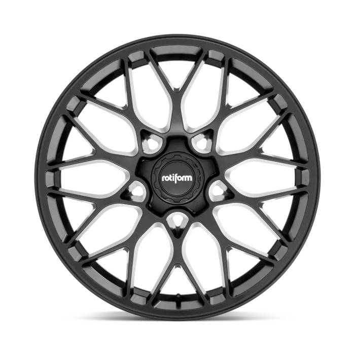 A black Rotiform wheel with an intricate, geometric spoke design is shown against a white background, highlighting the hub where the brand "rotiform" is prominently displayed.