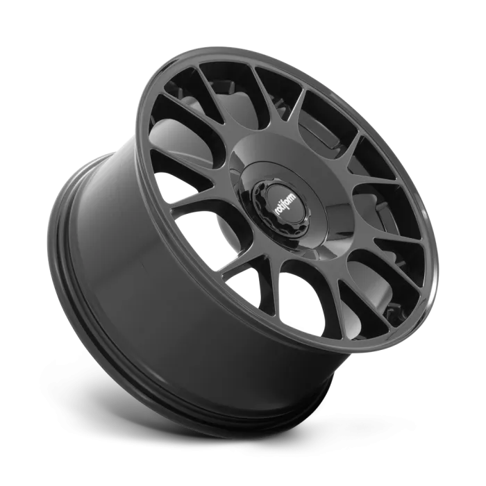 A black alloy wheel with an intricate multi-spoke design rests against a plain background; the central cap features the word "rotiform."