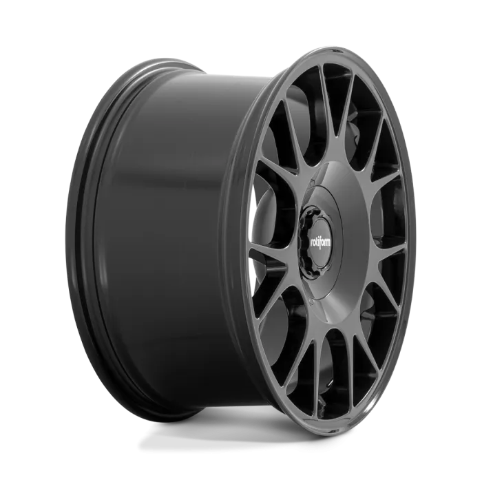 A black, multi-spoke wheel (racing or automobile) is positioned against a plain background. The center cap features the logo "rotiform."