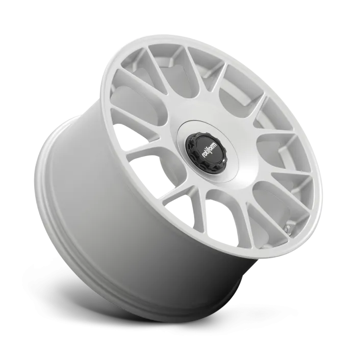 Silver alloy car wheel with a multi-spoke design, featuring a black center cap labeled “rotiform”; displayed against a white background. The wheel is positioned at an angle.