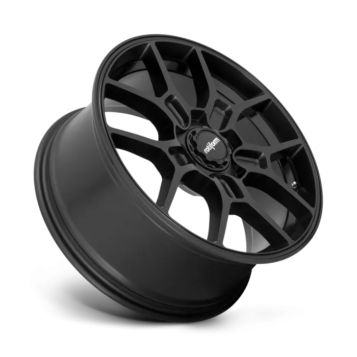 A black, multi-spoke car wheel rim is angled with the "rotiform" logo at the center. The background is a gradient of gray, highlighting the metallic finish.