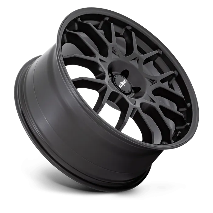 A matte black car wheel rim with a multi-spoke design lies at an angle against a plain black background; the center cap displays the text "rotiform."