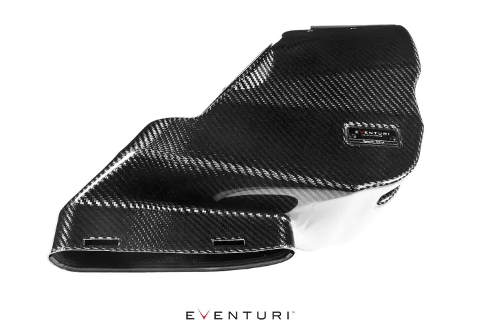 Carbon fiber engine cover with a glossy finish, featuring an embossed label "EVENTURI" and "MADE IN ENGLAND" and "Patented Design Delta". Set against a white background.