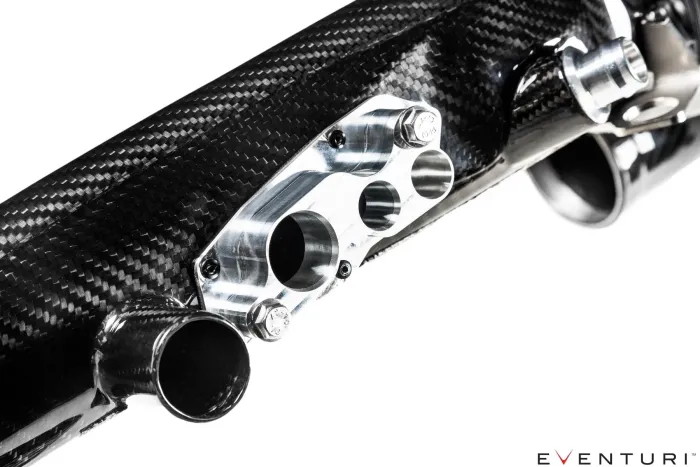 Carbon fiber automotive intake system with aluminum mounting bracket and multiple tubes, viewed close-up against a white background. Text in the bottom right corner: "EVENTURI"
