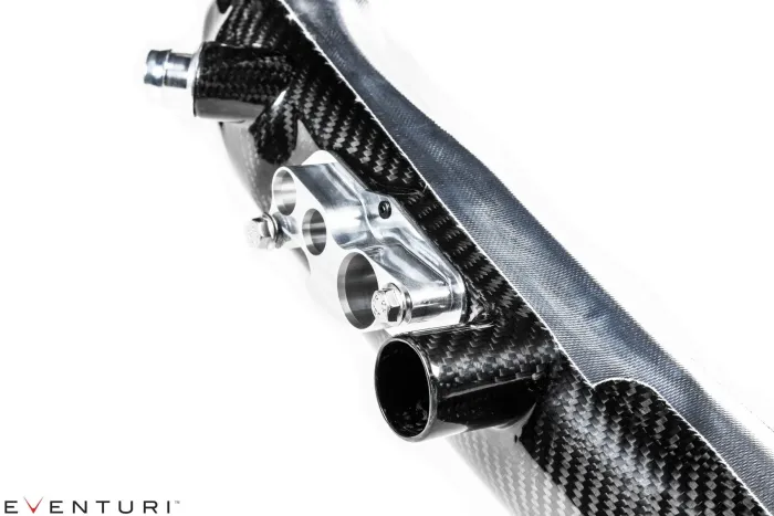 A polished metal component with bolts attached to a carbon fiber structure, positioned against a white background. Branding “EVENTURI” in the bottom left corner.