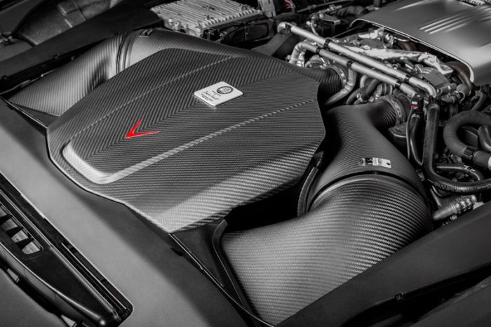 Engine showcasing a carbon fiber air filter cover and intake system, situated within the engine bay of a high-performance vehicle.