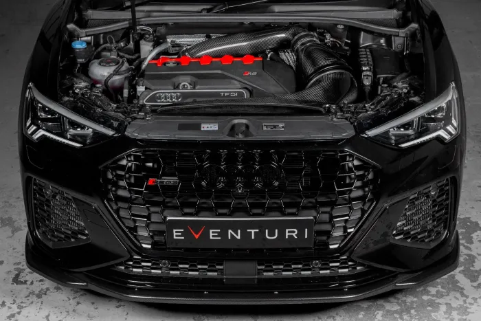 The front view of a black Audi RS3, hood open, showcasing the engine and carbon fiber air intake system with a prominent "EVENTURI" logo on the lower grille.
