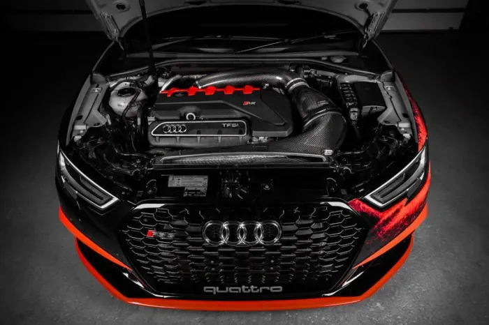 A high-performance Audi engine, with an open hood, displays the TFSI engine labeled "quattro" in a dimly lit garage.