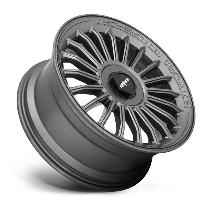 A matte gray car wheel with a multi-spoke design rests on its side. Text on the wheel’s outer edge reads "MOTORSPORT ROTIFORM," and the center cap shows the "rotiform" logo.
