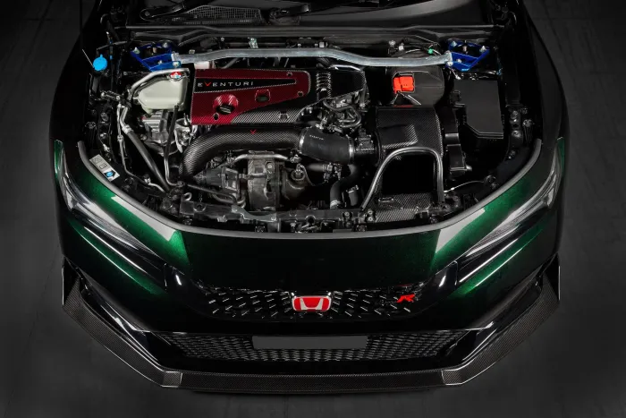 Car engine compartment with a red "EVENTURI" air intake system. The car is dark green, with a Honda emblem on the front grille. The surroundings appear to be a garage.