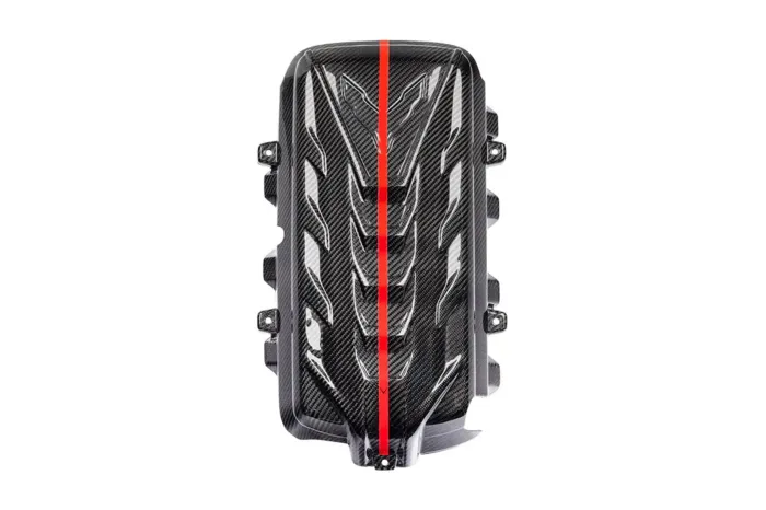 Carbon fiber engine cover with black and gray diagonal pattern, featuring a central bright red stripe. The cover has multiple mounting points and raised ridges, against a white background.