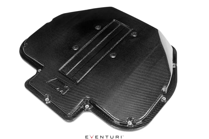 Carbon fiber engine cover with vent slots lying horizontally, surrounded by a white background. Below it, the text "EVENTURI."