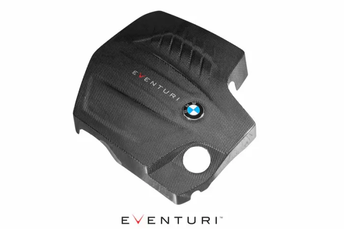 A black carbon-fiber engine cover with the words “EVENTURI” and a BMW logo rests on a white background, with "EVENTURI" written again at the bottom.