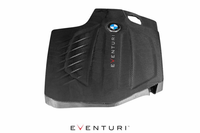 A black carbon fiber engine cover featuring a BMW logo and the word "EVENTURI." It is photographed on a white background with "EVENTURI" also written below.
