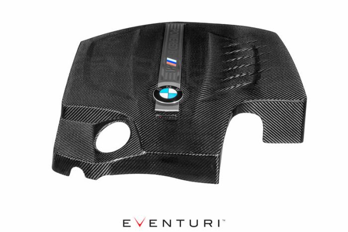 A carbon-fiber engine cover featuring a BMW logo and "Eventuri" branding. The cover includes a circular cutout and sculpted contours. The background is white with "EVENTURI" text below it.