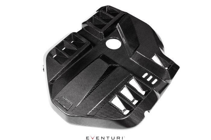 Carbon fiber engine cover with geometric patterns, vent openings, and a central circular cutout, displayed against a white background. Text: "EVENTURI."