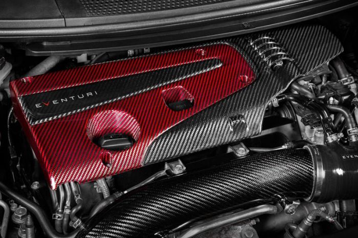 The image shows a car engine bay featuring a red and black carbon fiber engine cover labeled "EVENTURI," surrounded by various metal engine components and pipes.