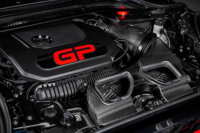A high-performance car engine labeled "GP" with black and carbon fiber components in a well-organized engine bay.