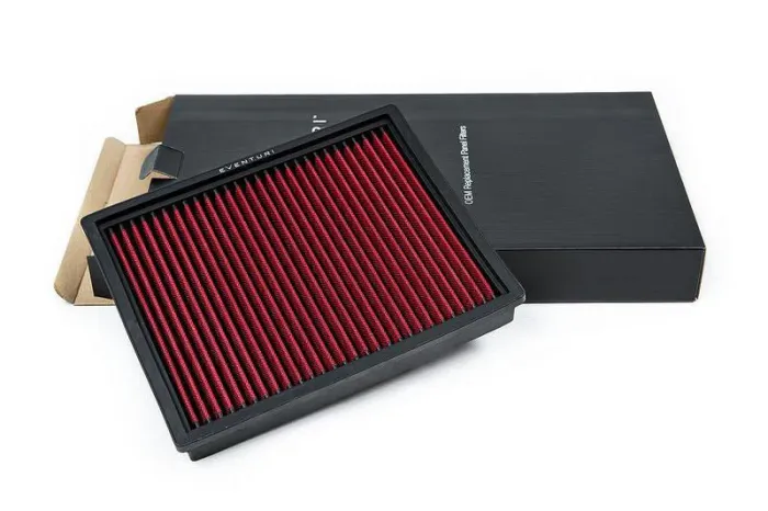A red, rectangular air filter rests angled on top of a black box. Text on the box's edge reads "G80 Replacement Panel Filter."