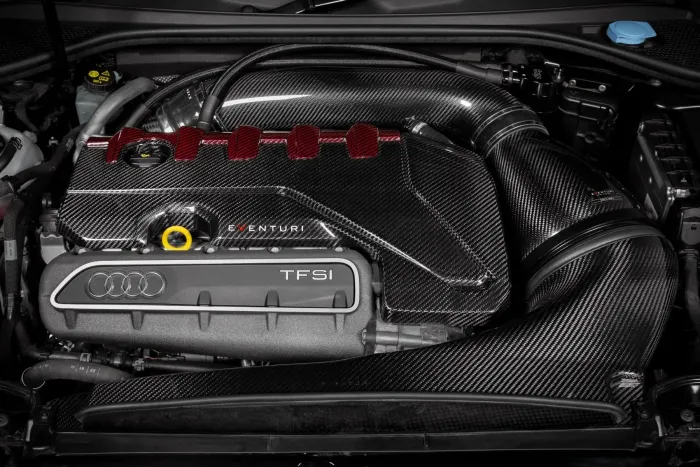 Carbon fiber air intake system labeled “EVENTURI” with flexible ducting connects to a “TFSI” Audi engine cover in a car engine bay, featuring pipes, caps, and various components.