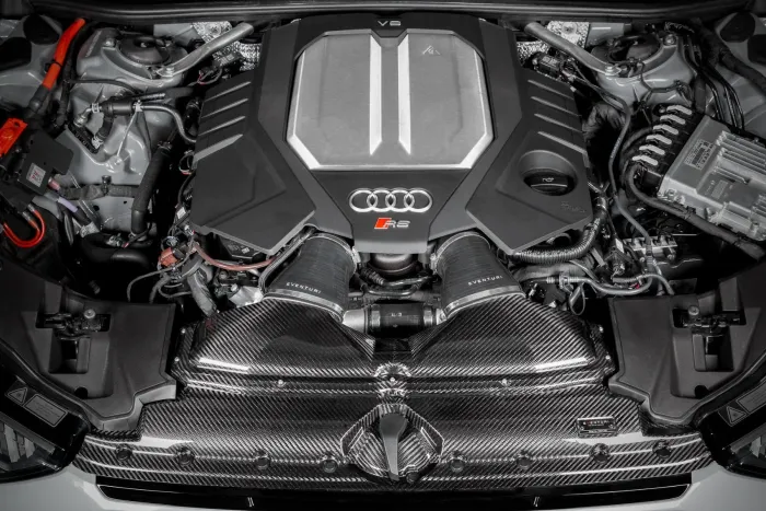 A V6 engine with an "S" badge and the Audi logo is fitted with Eventuri components, situated in a sleek car engine bay with visible wiring and metallic elements.