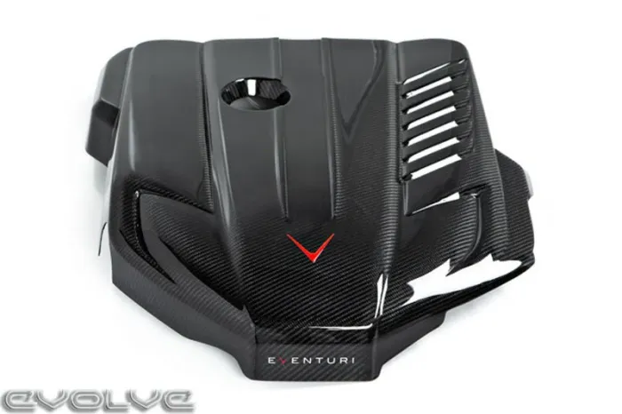 A carbon fiber car engine cover with sleek, angular designs, a small circular cut-out, red V emblem, and slotted vents, labeled "EVENTURI." The "EVOLVE" logo appears in the bottom left.